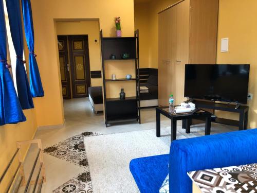 a living room with a blue couch and a television at White House in Pleven
