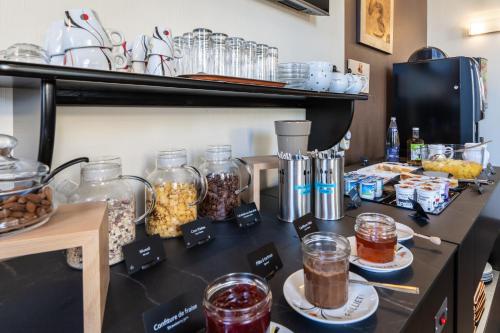 a counter with jars of food and other items on it at Hotel des Ducs in Alençon