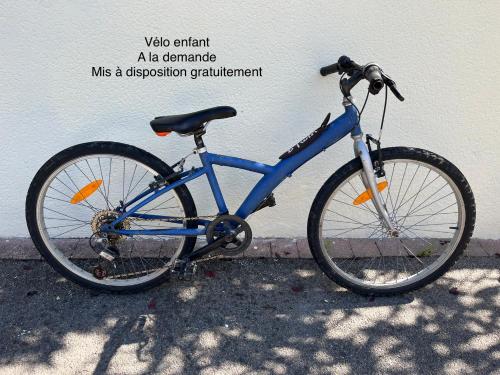 un vélo bleu garé à côté d'un mur dans l'établissement Ar Kevel, à La Baule