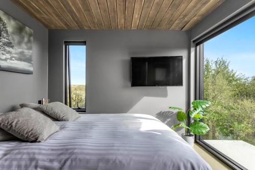 a bedroom with a bed and a large window at Luxurious 4BR Summerhouse with Hot Tub and Sauna in Selfoss
