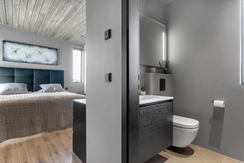 y baño con cama, aseo y lavamanos. en Luxurious 4BR Summerhouse with Hot Tub and Sauna en Selfoss