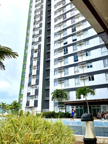 a large apartment building with a pool in front of it at City View Studio Unit at Centrio Tower beside Ayala Mall in Cagayan de Oro