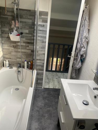 une salle de bain avec une baignoire, un lavabo et un miroir dans l'établissement Chez Anna2, à Bandol