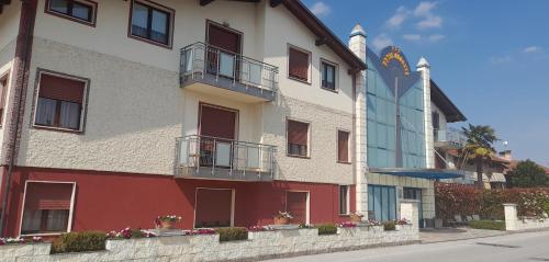 - un bâtiment rouge et blanc avec balcon dans une rue dans l'établissement Hotel Ceretto, à Busca