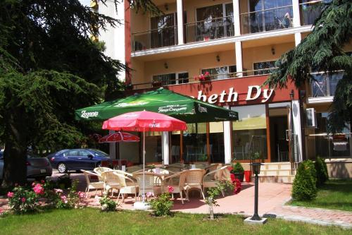 a cafe with chairs and an umbrella in front of a hotel at Elizabeth Dy Boutique Hotel in Nesebar