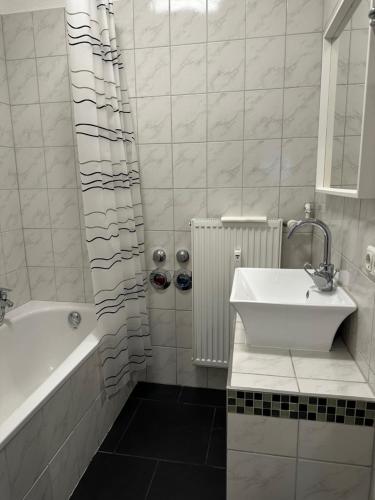 ein Badezimmer mit einer Badewanne, einem Waschbecken und einer Badewanne in der Unterkunft Wohnung am Marktplatz in Gießen