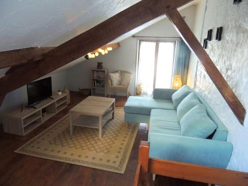 a living room with a blue couch and a table at Bienvenue à La Sélinière ! in Champ-du-Boult