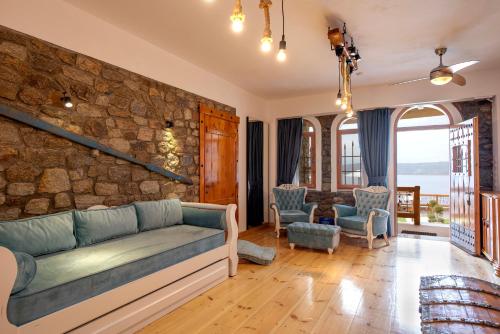 a living room with a couch and a stone wall at Ammou Area in Ammouliani