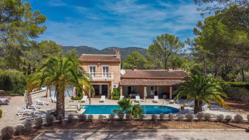 une maison avec une piscine et des palmiers dans l'établissement Grande Villa entre Cannes St Tropez, à Puget-sur Argens