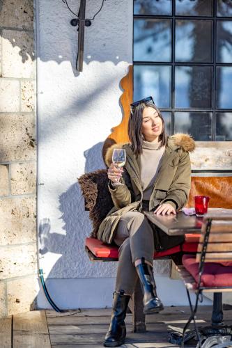 a woman sitting at a table with a glass of wine at Le Coucou Hotel Restaurant & Lounge-Bar in Montreux
