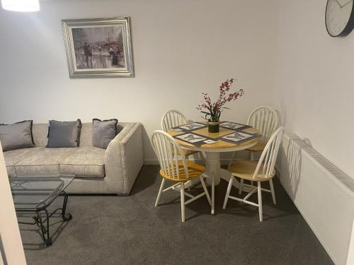 a living room with a table and chairs and a couch at Clavens House in Glasgow