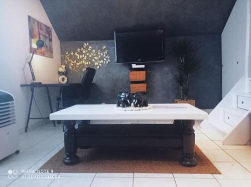 a white table with a tv on top of it at Le Duplex Décontracté in Fleury-les-Aubrais