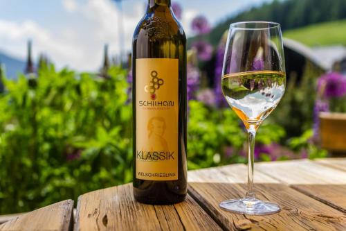 a bottle of wine and a glass on a table at Gasthof-Appartements Sportalm in Bad Kleinkirchheim