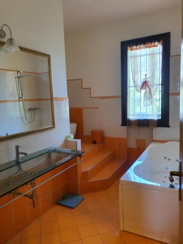 a bathroom with a tub and a sink and a mirror at Villa Elsa, Cesena zona Ippodromo in Cesena