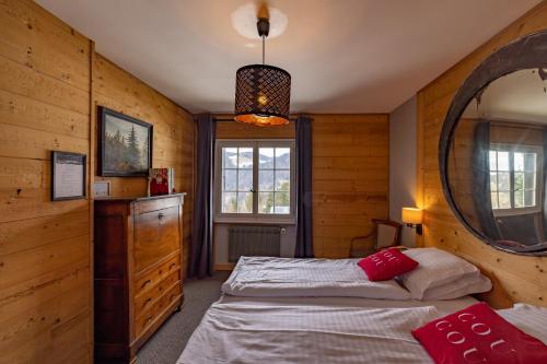 1 Schlafzimmer mit 2 Betten und einem Spiegel in der Unterkunft Le Coucou Hotel Restaurant & Lounge-Bar in Montreux