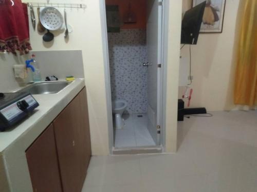 a bathroom with a sink and a shower with a toilet at A Parallag apartment in Manila