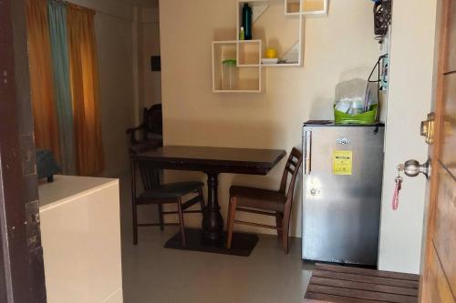 a small kitchen with a table and a refrigerator at A Parallag apartment in Manila
