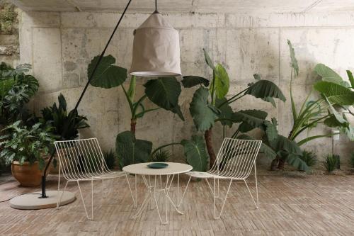 two chairs and a table in a room with plants at Pátio do Tijolo in Lisbon