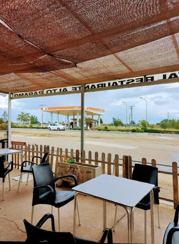 a gas station with tables and chairs in front of a gas station at HOSTAL ALTO PÁRAMO in Villadangos del Páramo