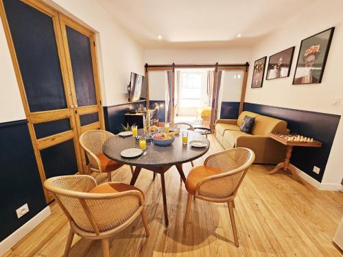un salon avec une table, des chaises et un canapé dans l'établissement Le cinéaste -Terrasse -Vivre au coeur d'Angouleme, à Angoulême