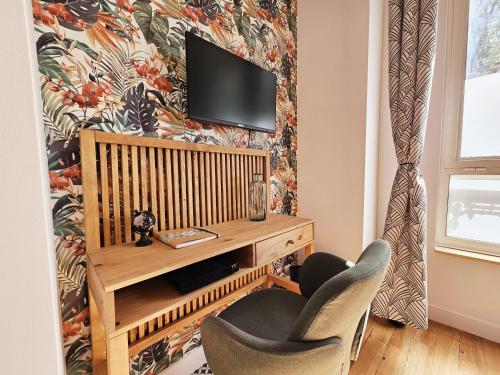 - un salon avec une télévision et deux chaises dans l'établissement Le cinéaste -Terrasse -Vivre au coeur d'Angouleme, à Angoulême