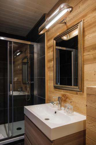 a bathroom with a sink and a shower and a mirror at Le Coucou Hotel Restaurant & Lounge-Bar in Montreux