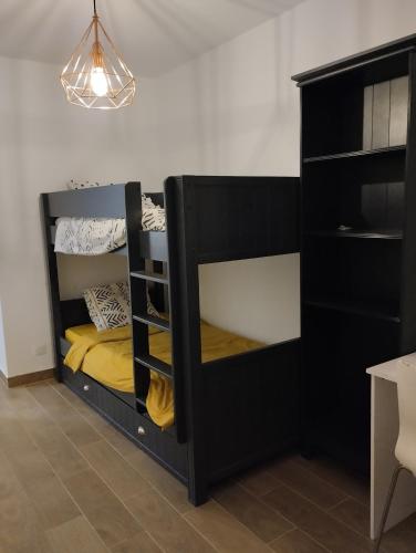 Ce lit superposé noir se trouve dans un dortoir. dans l'établissement Superbe appartement argenteuil gare du val, à Argenteuil