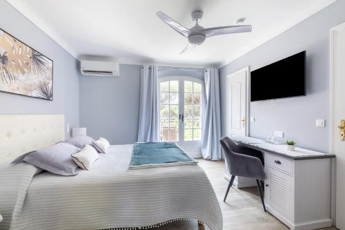 a white bedroom with a bed and a desk at Chambres d'Hotes Les Amandiers in Saint-Tropez