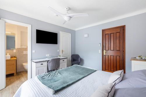 a white bedroom with a bed and a bathroom at Chambres d'Hotes Les Amandiers in Saint-Tropez