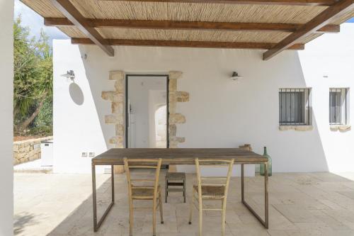 a wooden table and chairs on a patio at Trullo Vicino al Mare in Ostuni
