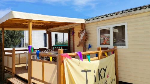 a house with a porch with a tent on it at Camping Tikayan Félix de la Bastide in Saint-Mitre-les-Remparts