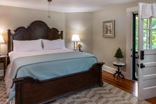 a bedroom with a large bed with a wooden headboard at Pinecrest Bed & Breakfast in Asheville