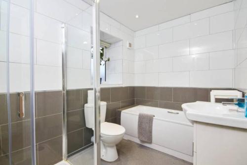 La salle de bains blanche est pourvue de toilettes et d'un lavabo. dans l'établissement Spacious Bristol Apartment - Parking & WIFI, à Bristol