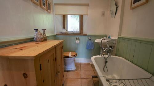 a bathroom with a tub and a sink and a toilet at View Cottage in Lochearnhead