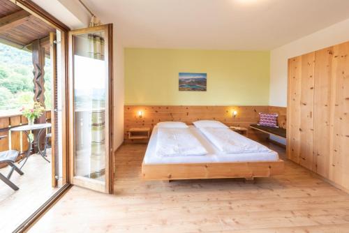 a bedroom with two beds and a balcony at Eich-hof in Caldaro