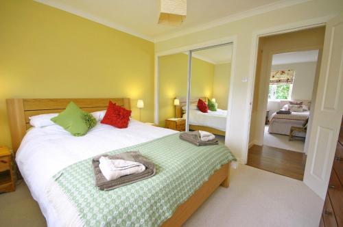 a bedroom with a bed with green and red pillows at Tomanour in Comrie