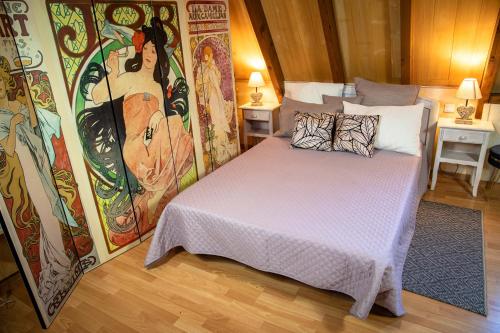 um quarto com uma cama com um quadro na parede em Gite la vigne 4 à 10 personnes Domaine Saint Raphaël em Prats-de-Carlux