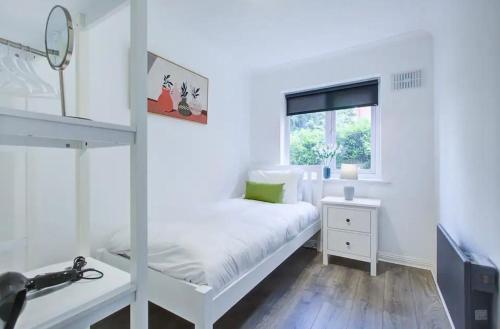 a small bedroom with a white bed and a window at Spacious 2 Bedroom Apartment in London