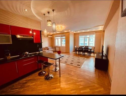 a kitchen and living room with red cabinets and a table at Park azure in Baku