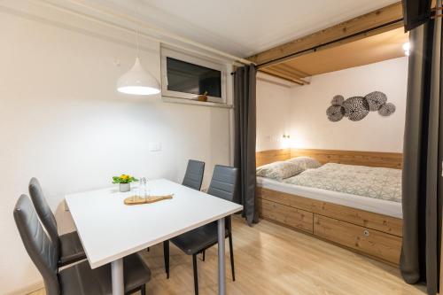 a room with a table and chairs and a bed at Apartmaji Taler in Bohinj