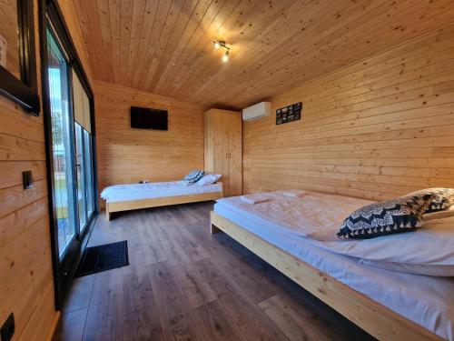 a bedroom with two beds in a wooden cabin at CASA ȘINCU in Cristian