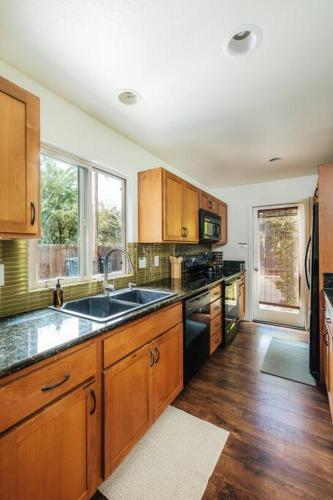 a large kitchen with wooden cabinets and a sink at The Kumu House in Kailua-Kona