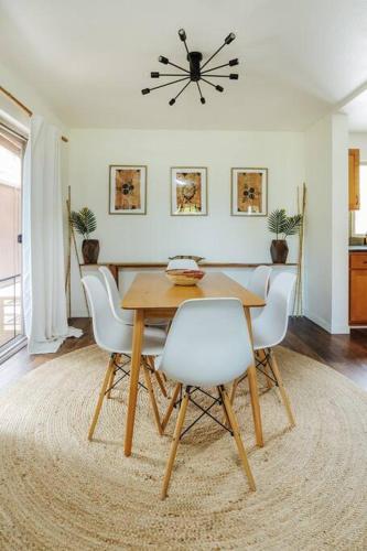 a dining room with a table and white chairs at The Kumu House in Kailua-Kona