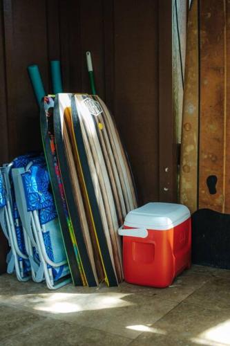 a pile of books sitting next to a red cooler at The Kumu House in Kailua-Kona