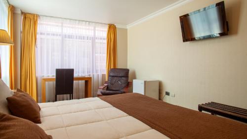 una habitación de hotel con una cama y una silla en HOTEL EL DORADO, en Concepción
