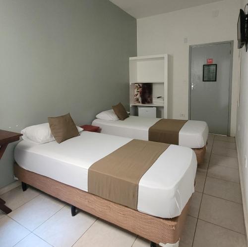 2 camas en una habitación de hotel con en Hotel Dona Lú, en São Paulo