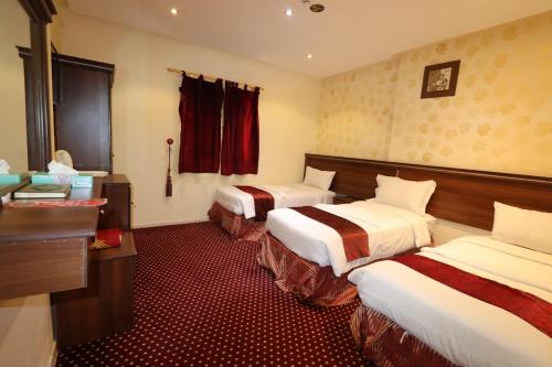 a hotel room with two beds in a room at Ayan ALMUEABADH -1700m to ALharam in Mecca