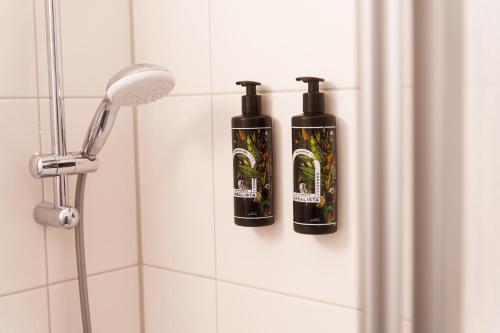 zwei Flaschen Shampoo stehen an einer Wand in einer Dusche in der Unterkunft Reeperbahn Unique Boutique Apartments in Hamburg