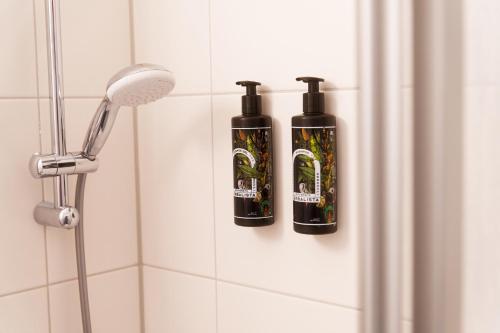 two bottles of shampoo are sitting on a wall in a shower at Reeperbahn Unique Boutique Apartments in Hamburg