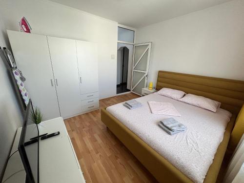 een kleine slaapkamer met een bed en een spiegel bij SJ Apartment in Tulcea